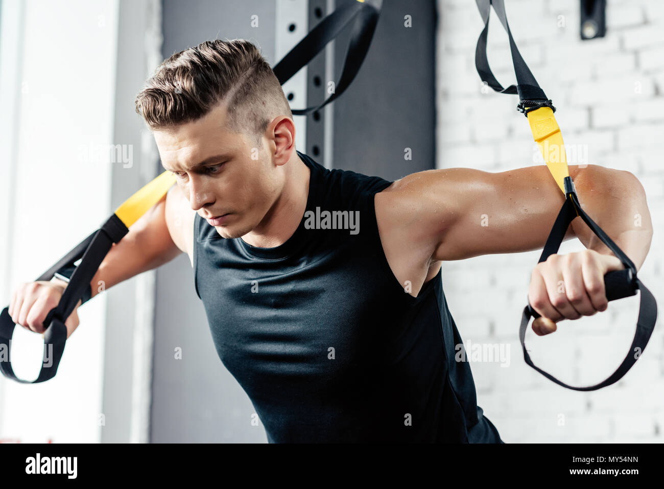 young muscular sportsman training with trx resistance bands in gym Stock  Photo - Alamy