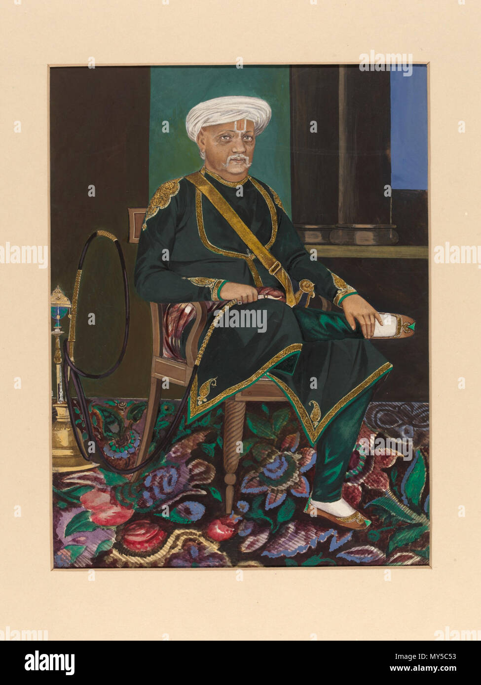 . English: This Company Painting is a portrait of Thakur Bhoj Raj Singh seated on a European chair holding the mouthpiece of a huqqa. It was drawn by an artist named Gopal at Agra in 1874 and bears a label on both the front and back giving the price as £4; it was acquired by the India Museum soon afterwards and transferred to the South Kensington Museum (now the V&A) in 1879. 'Thakur' is the title given to the son of a Rajput ruler who is deceased, but biographical details of the sitter have not been traced. 'Company paintings' were produced by Indian artists for Europeans living and working i Stock Photo