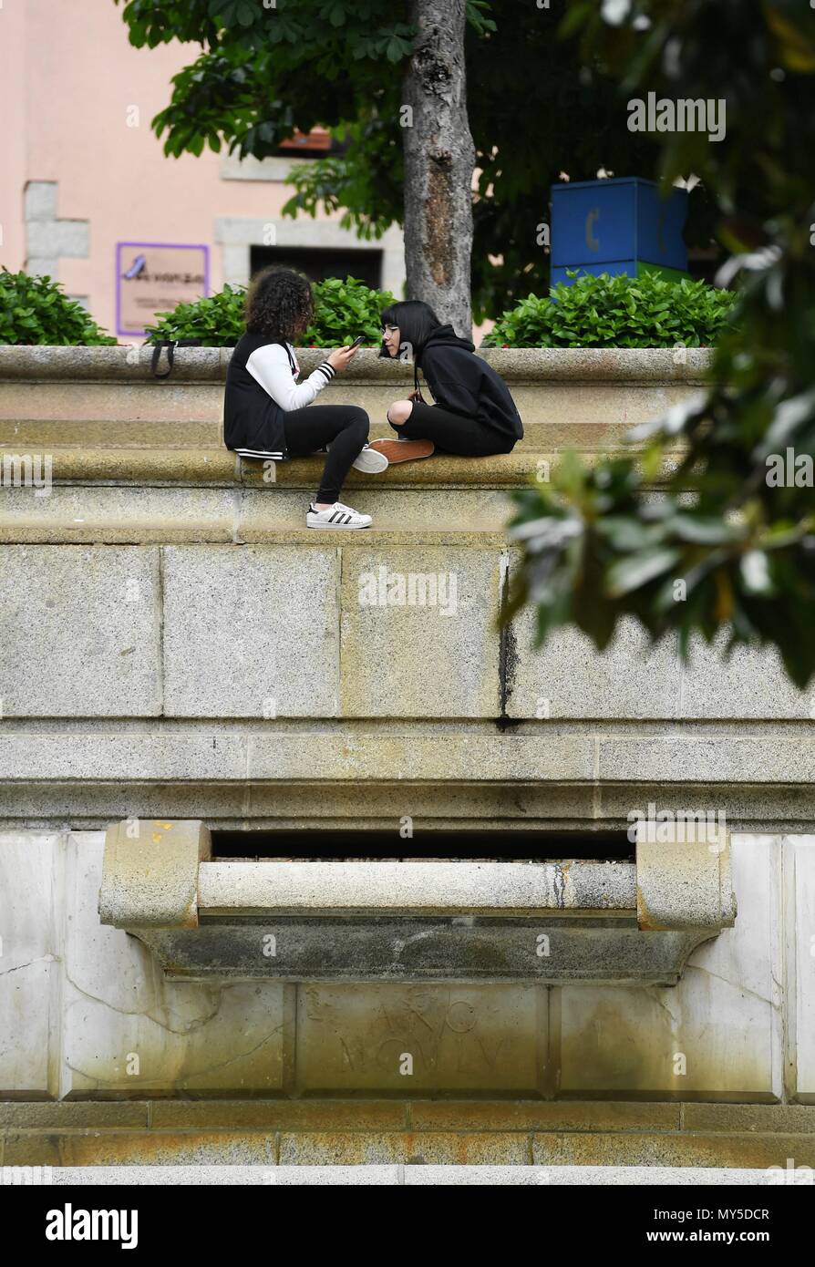 Madrid, Spain. 5th June, 2018. Two girls sit by a garden at El Escorial ...