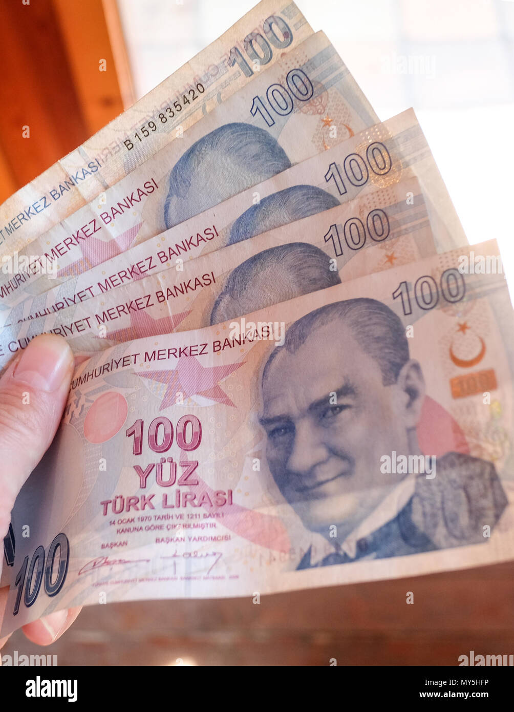 31.05.2018, Dalyan, Turkey: One hand holding 100 lira banknotes. In Turkey, inflation has risen following sharp falls in the country's currency lira. Photo: Jens Kalaene/dpa central image/dpa | usage worldwide Stock Photo