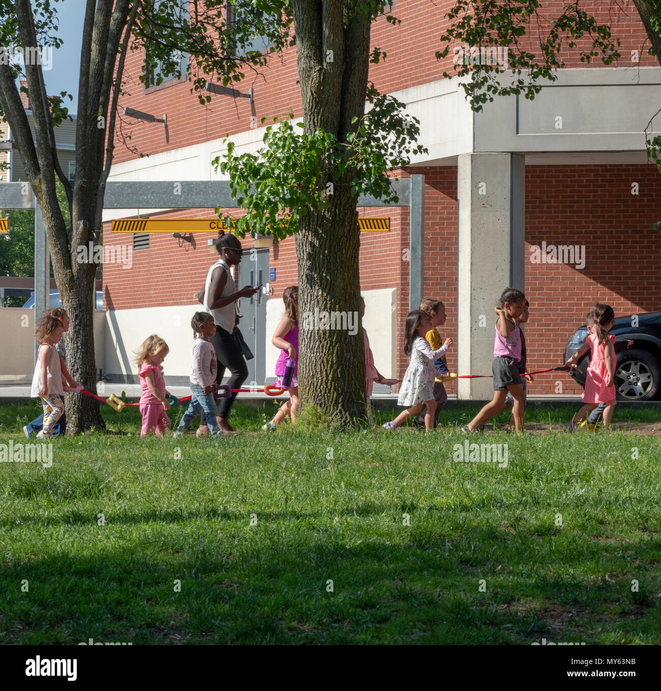 young pre-scheool children being escorted  with walking rope, Somerville, Massachusetts, USA Stock Photo