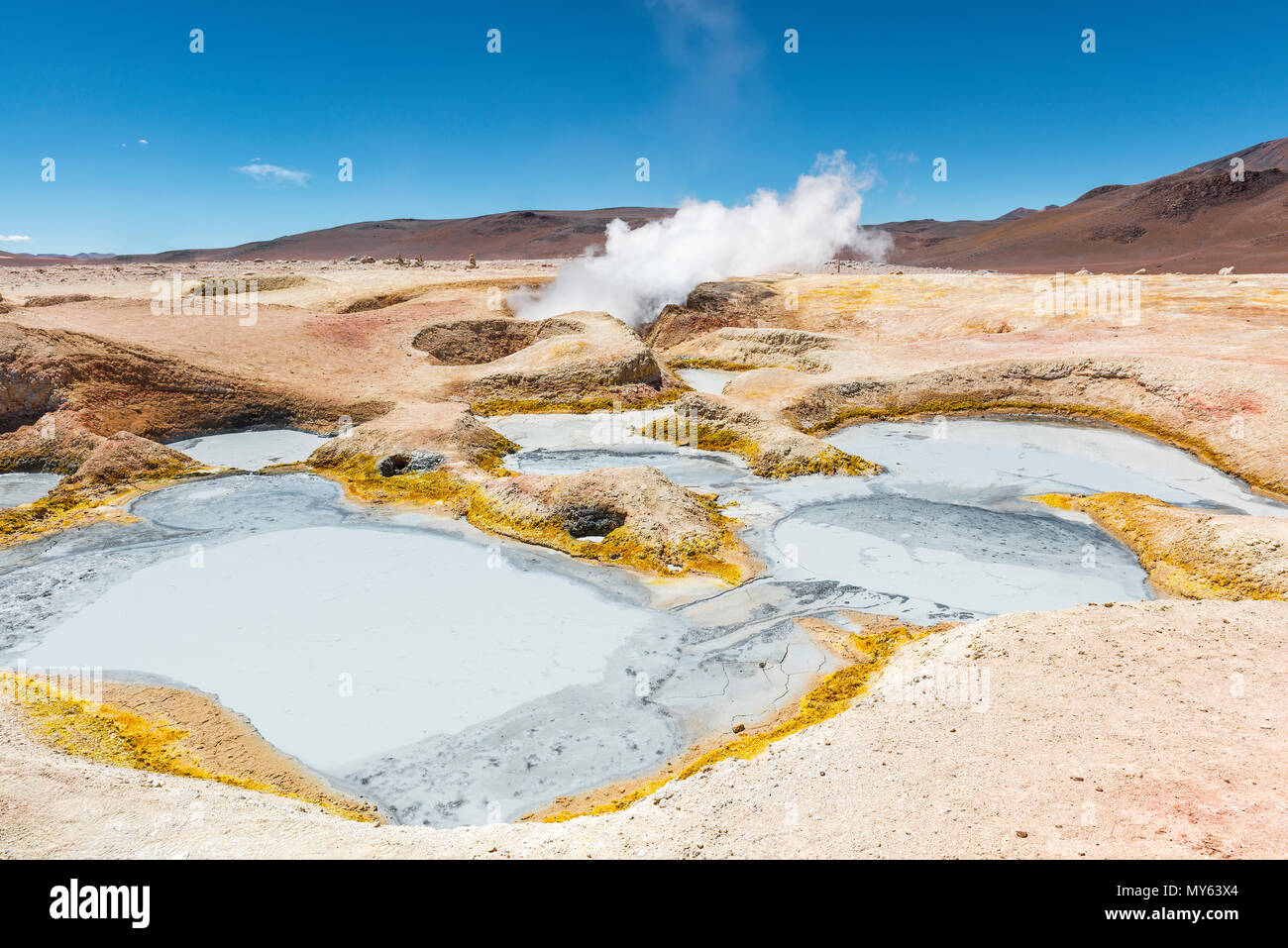 The volcanic activity of Sol de Mañana in Bolivia between Chile and the Uyuni Salt Flat. Mud pits and fumaroles with water vapor trails in the Andes. Stock Photo