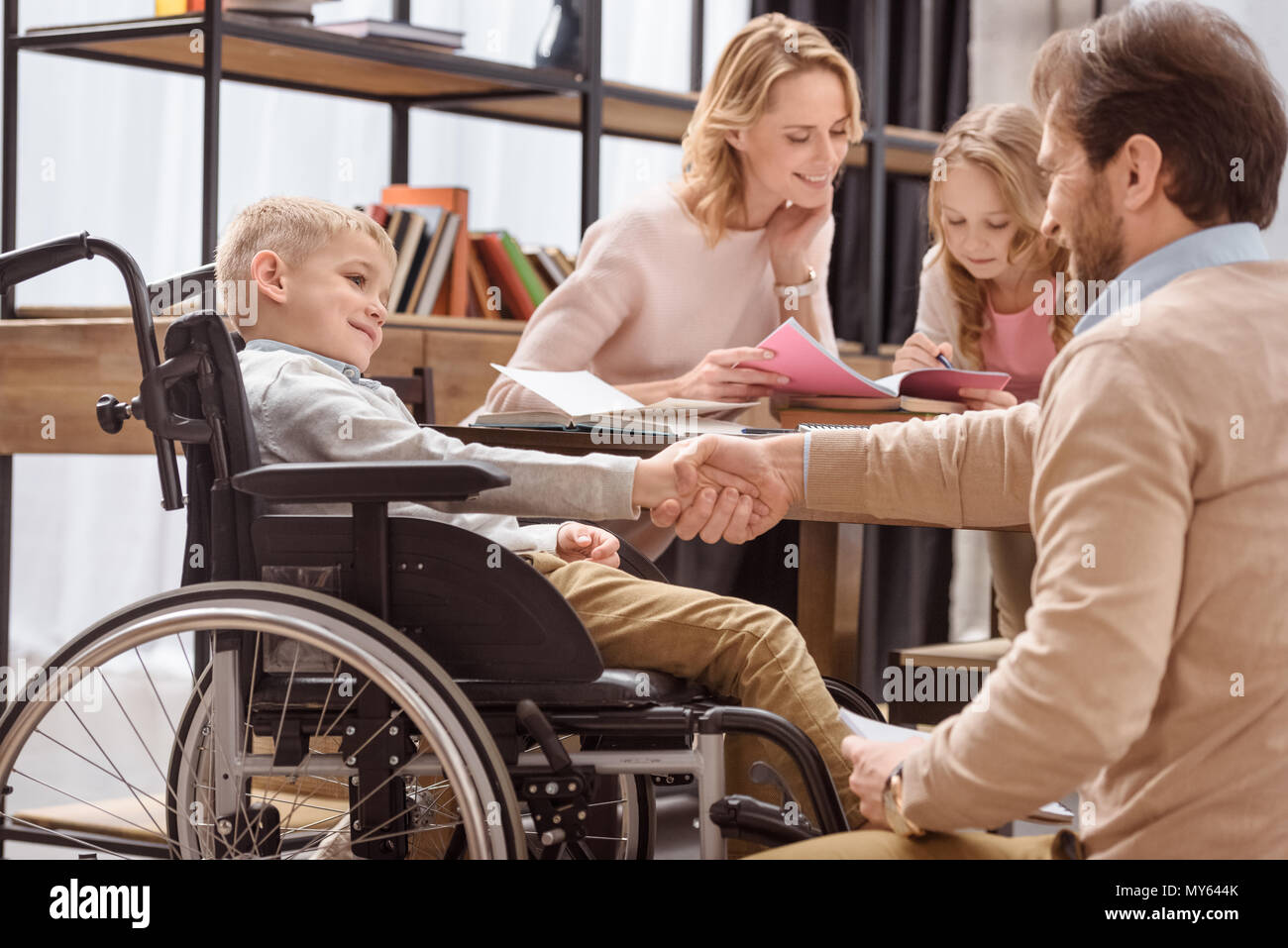 father and son on wheelchair shaking hands Stock Photo Alamy