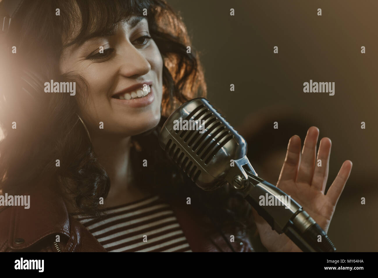 attractive young female singer performing song and smiling Stock Photo