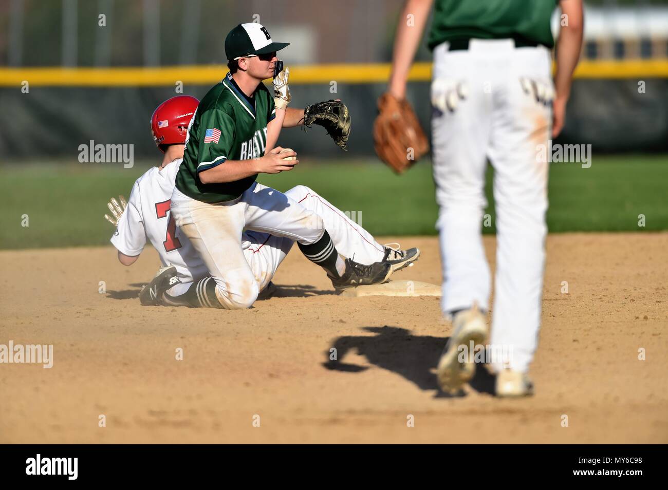 Second baseman looks to the base umpire for a call after attempting to complete a force play at second base. USA. Stock Photo