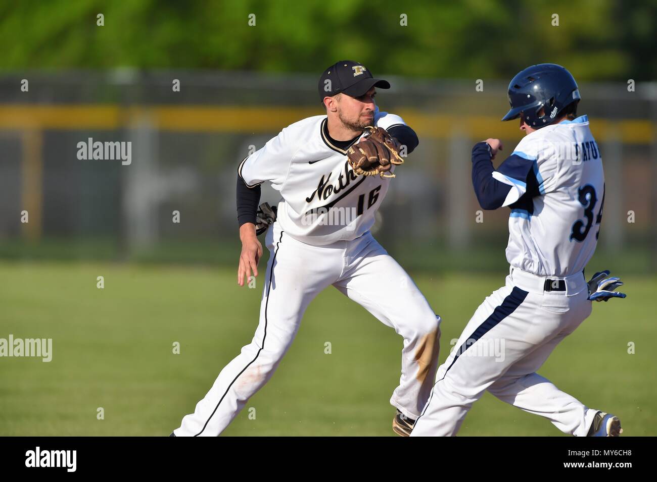 Shortstop reaching in front of an opposing runner to record a force out at second base. USA. Stock Photo