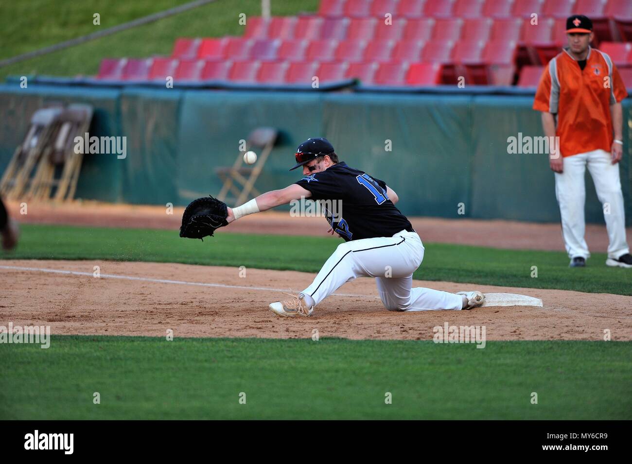 First baseman unable to dig out a low throw at first base. USA. Stock Photo