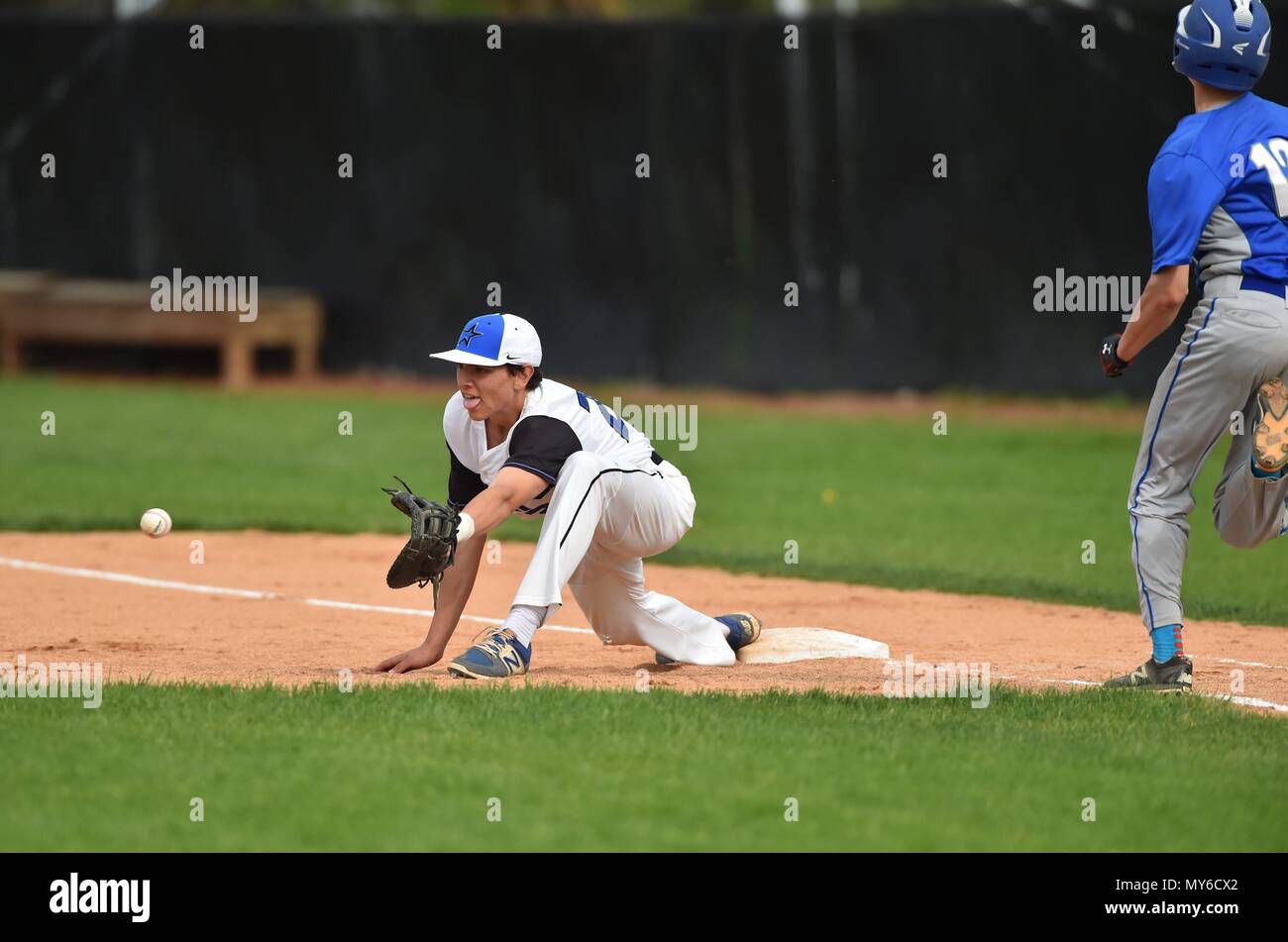 First baseman stretching to secure a throw from shortstop to retire an opposing hitter. USA. Stock Photo