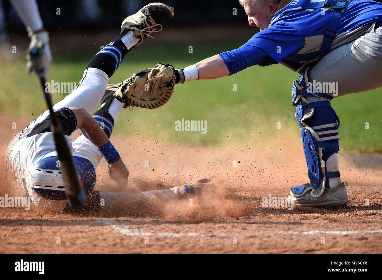 Runner scoring as the opposing catcher spins around to make a late tag