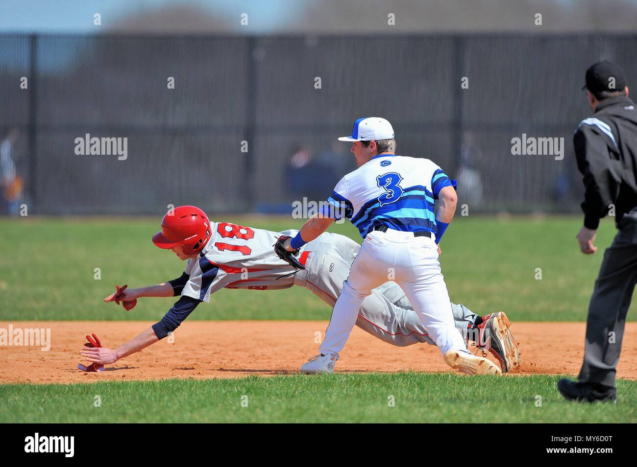 After being caught in a rundown between first and second a base runner is tagged out by an opposing infielder. USA. Stock Photo