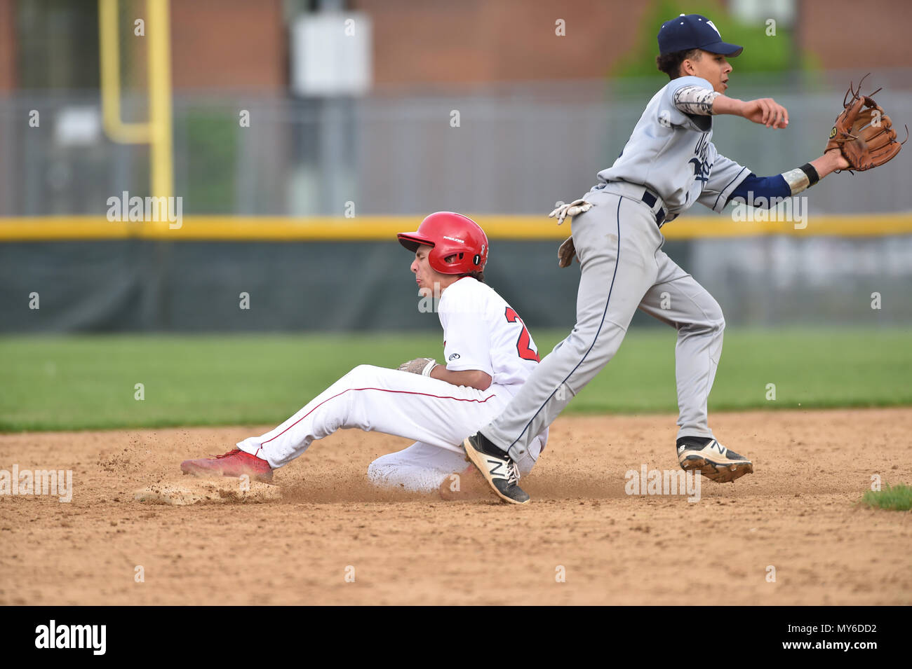 Middle infielder accepting a throw to late to prohibit an opponent base runner from stealing second base. USA. Stock Photo