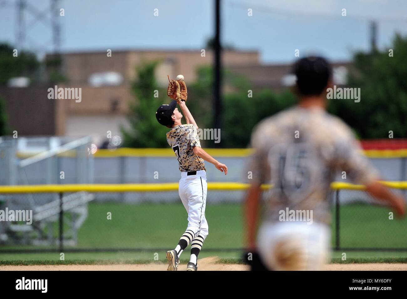 Second baseman making a running catch of a pop fly in short right-center field. USA. Stock Photo