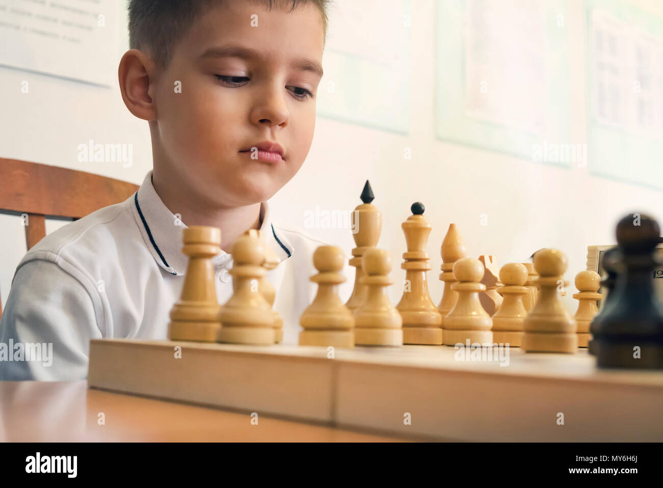 Premium Photo  Portrait of child during chess game boy plays chess and  thinks intently about the next move isolation on white background