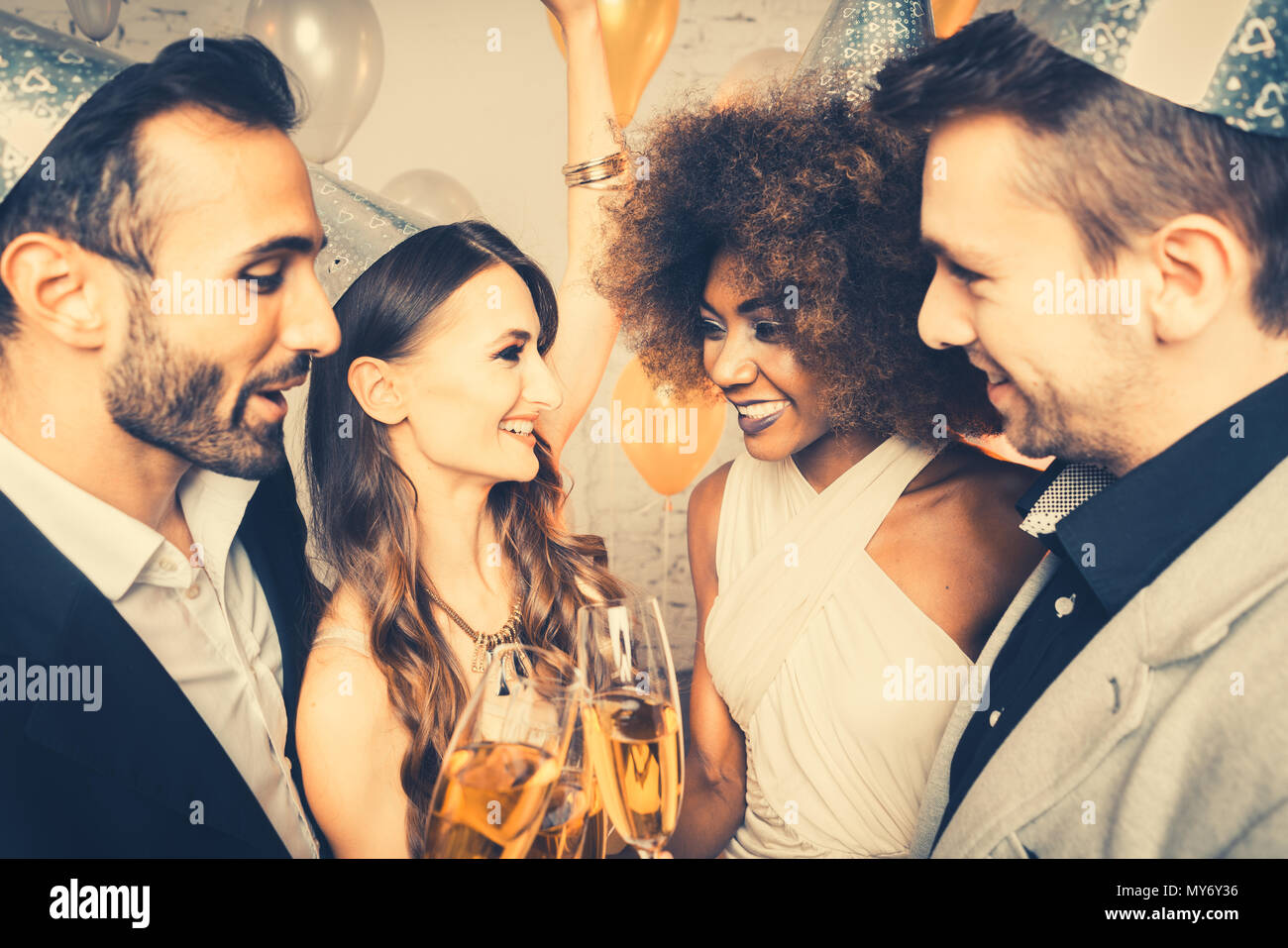 Men and women celebrating party while clinking glasses Stock Photo