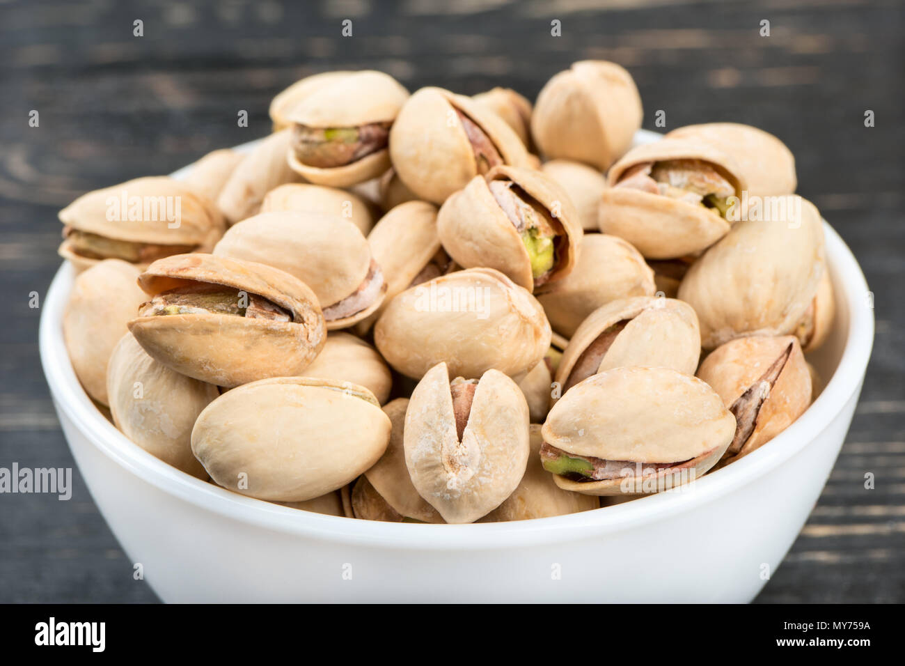 Ceramic bowl filled with pistachio nuts closeup Stock Photo