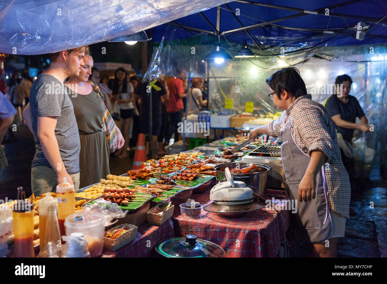 CHIANG MAI, THAILAND - AUGUST 27: Couple buys traditional Thai street food at the Saturday Night Market (Walking Street) on August 27, 2016 in Chiang Stock Photo