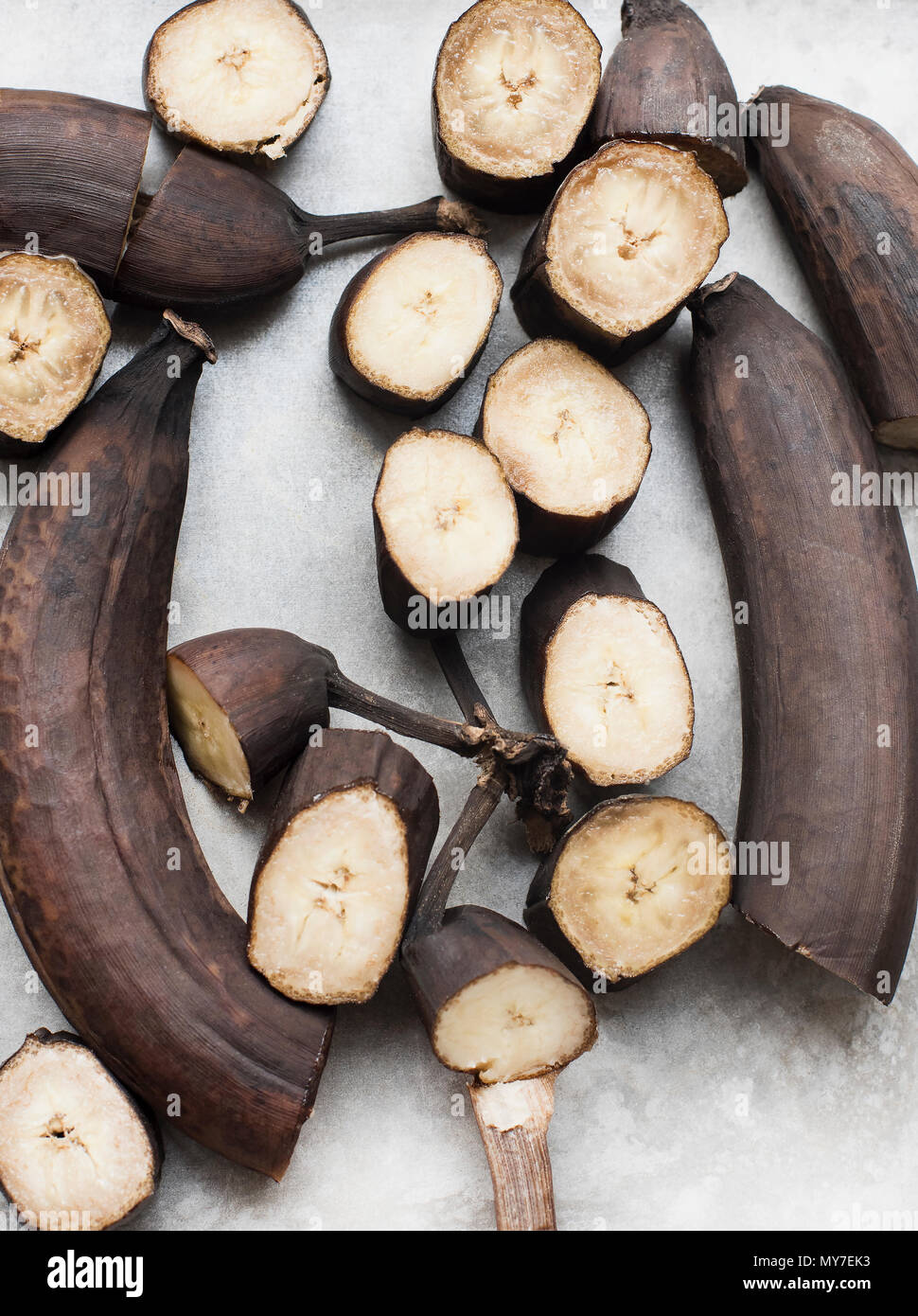 Still life of rotting bananas, sliced and whole, overhead view Stock Photo