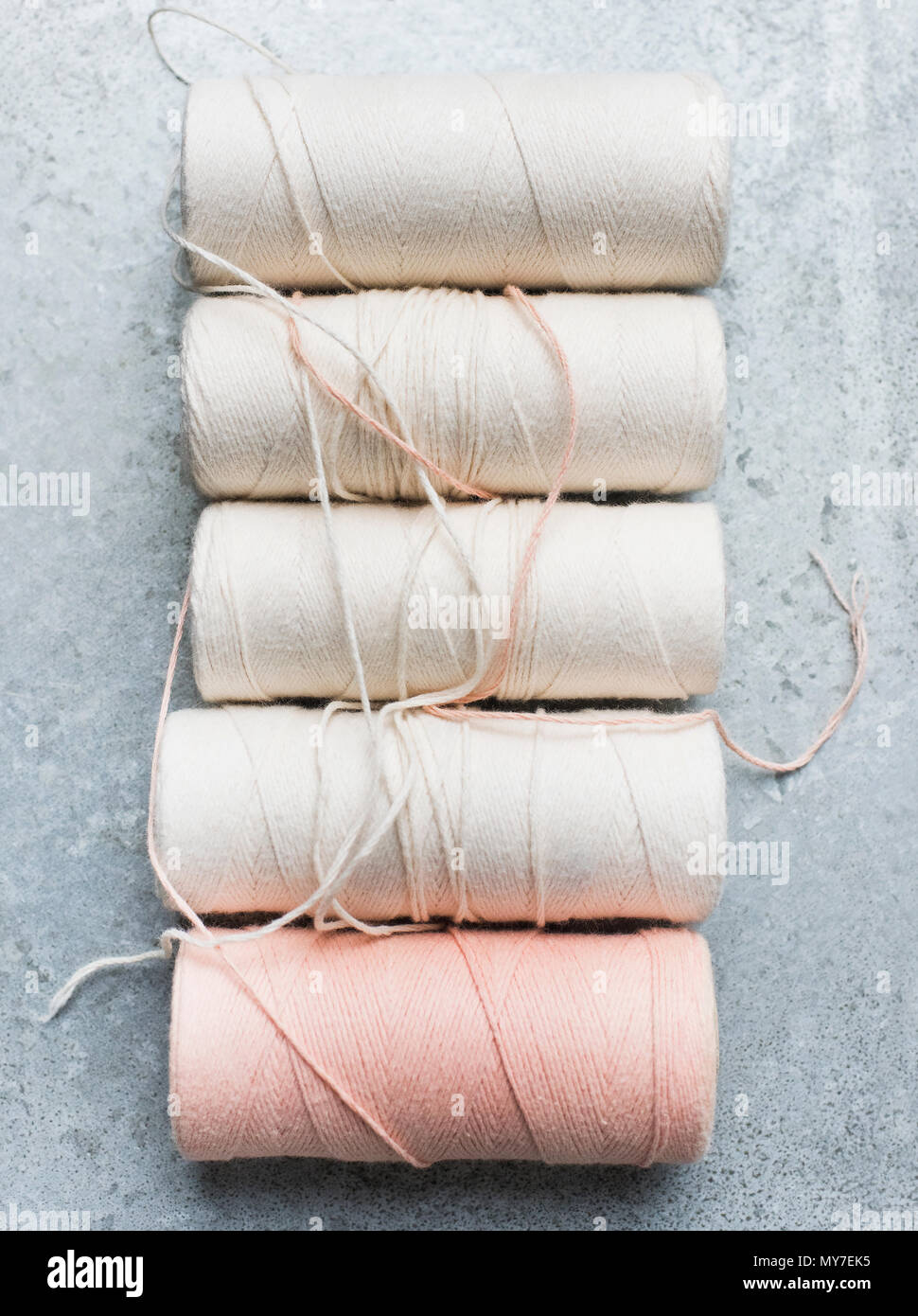 Still life with row of yarn spools, overhead view Stock Photo