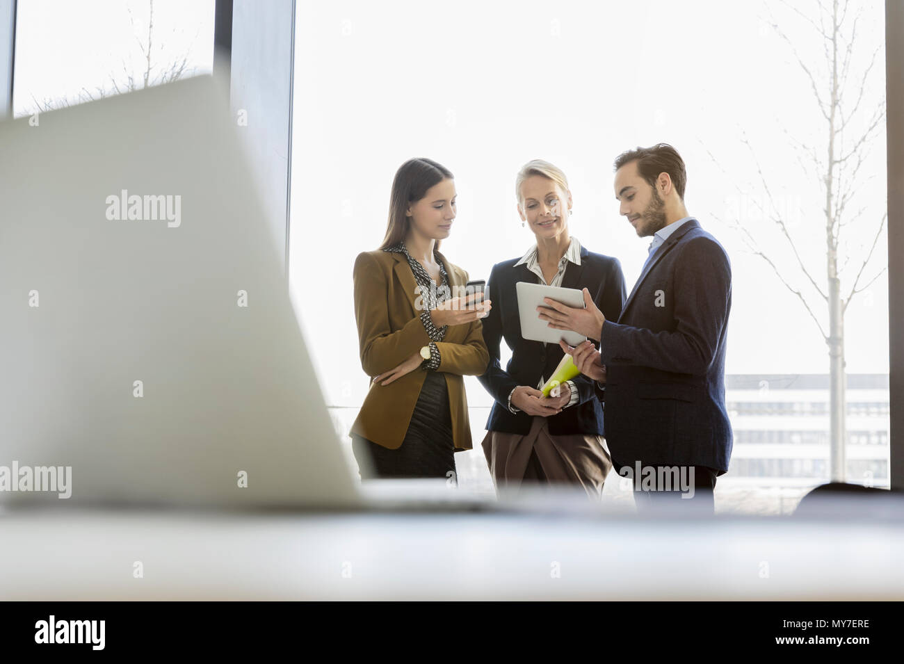 Colleagues chatting using digital tablet Stock Photo