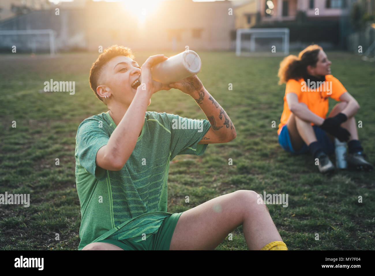 Football players taking break on pitch Stock Photo