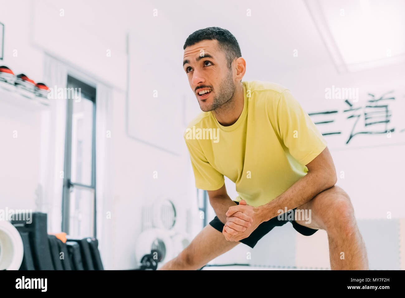 Man in gym doing stretching exercises Stock Photo