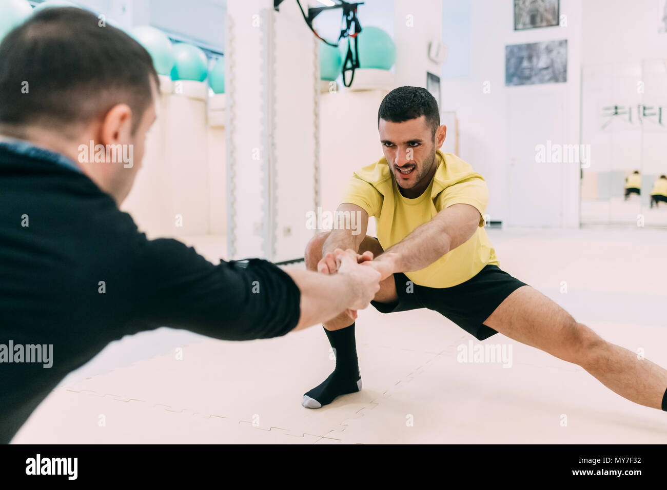 Men in gym doing stretching exercises Stock Photo