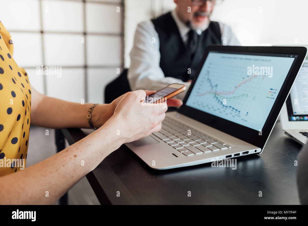 Woman using smartphone and laptop Stock Photo