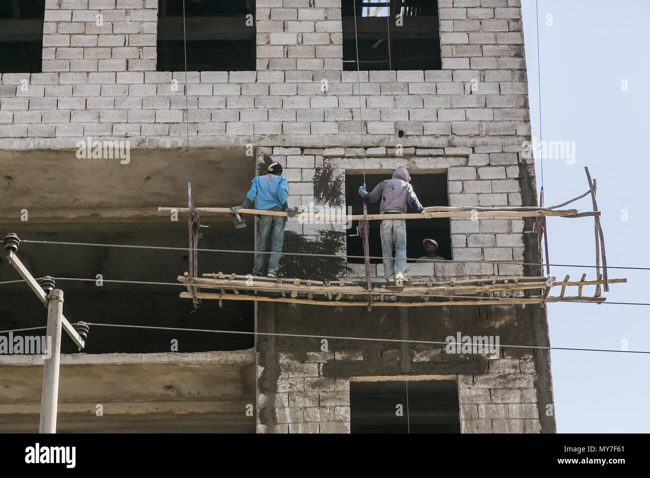 Addis Ababa, Ethiopia, January 30, 2014, Construction workers on a hanging scaffold Stock Photo