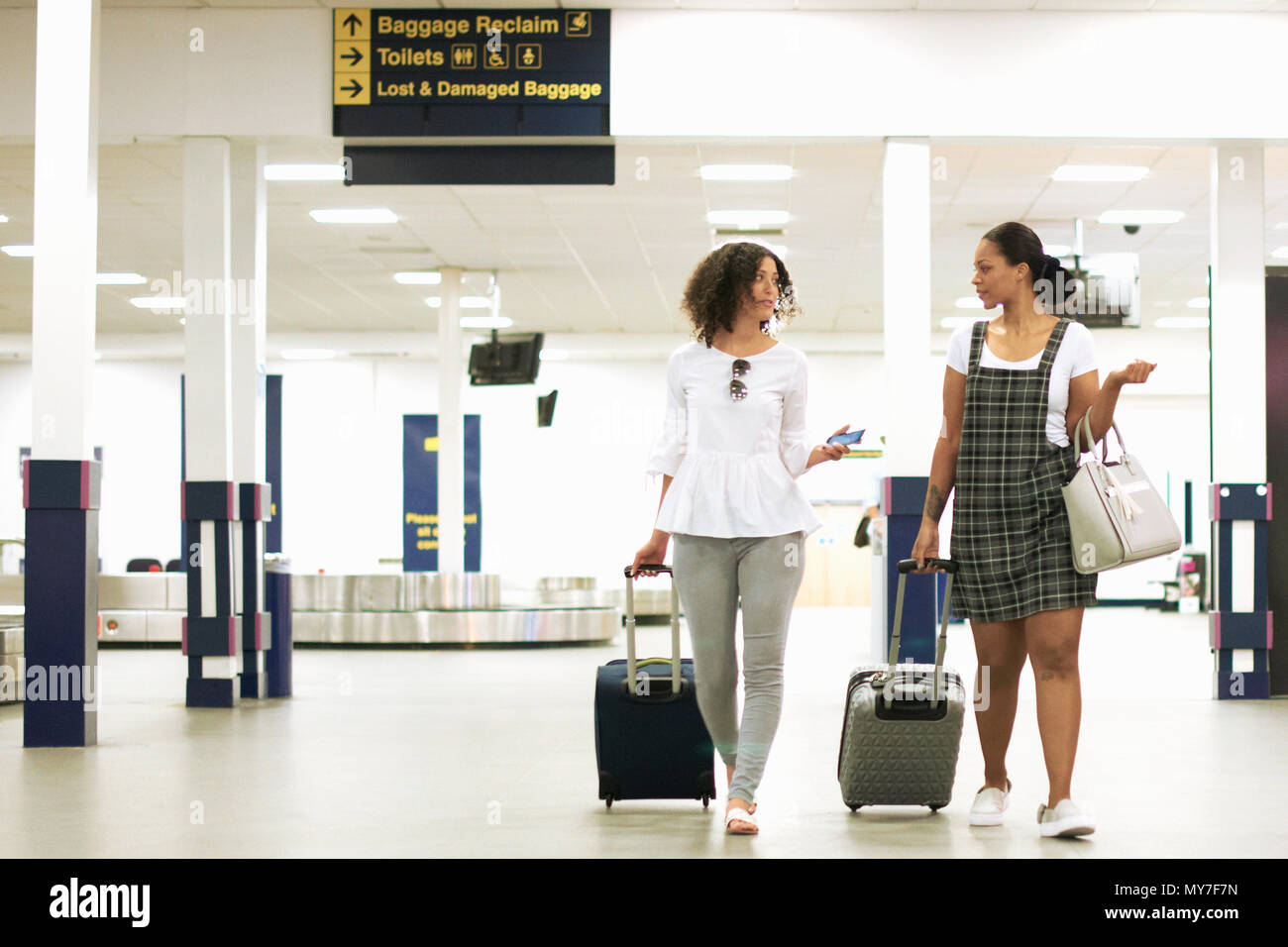 Friends with wheeled suitcases in airport Stock Photo