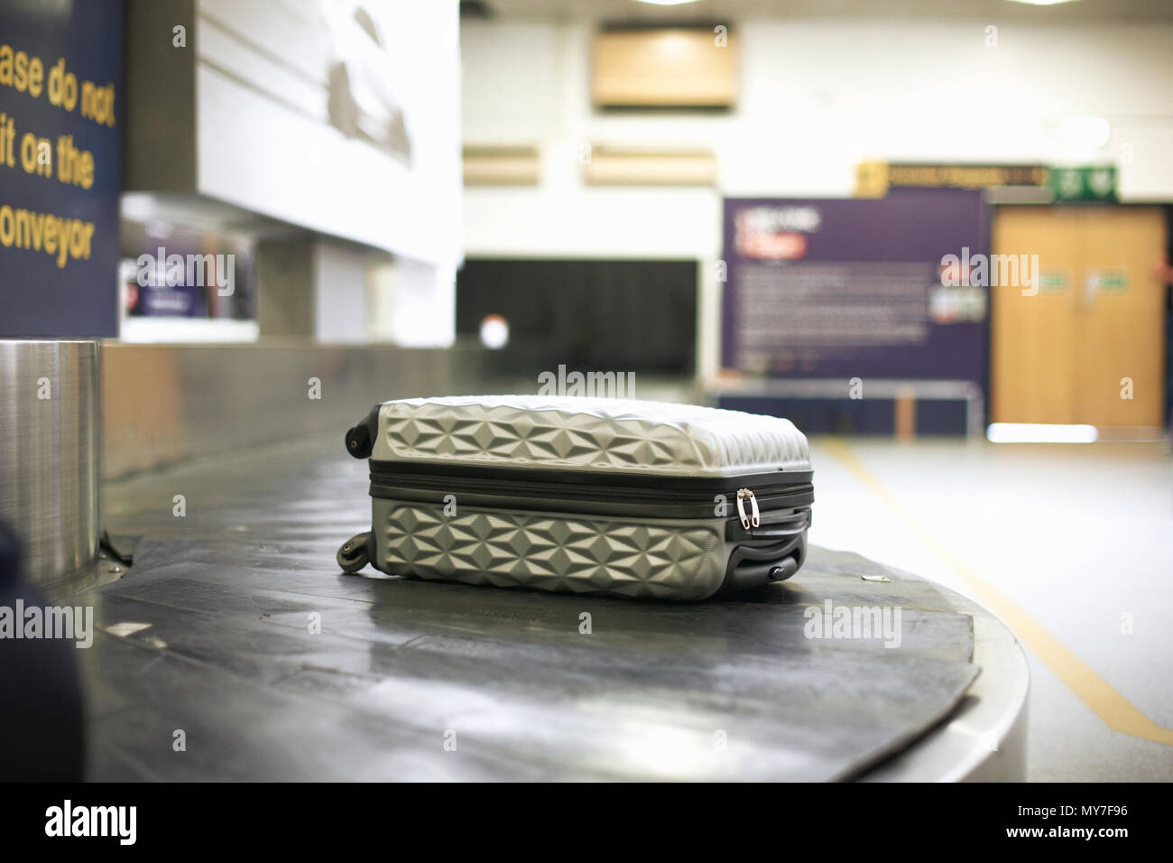 Wheeled suitcase on carousel in airport Stock Photo
