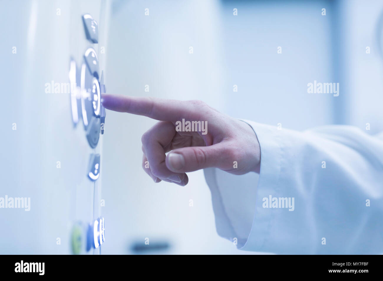 Person using control panel of CT scanner, close-up Stock Photo