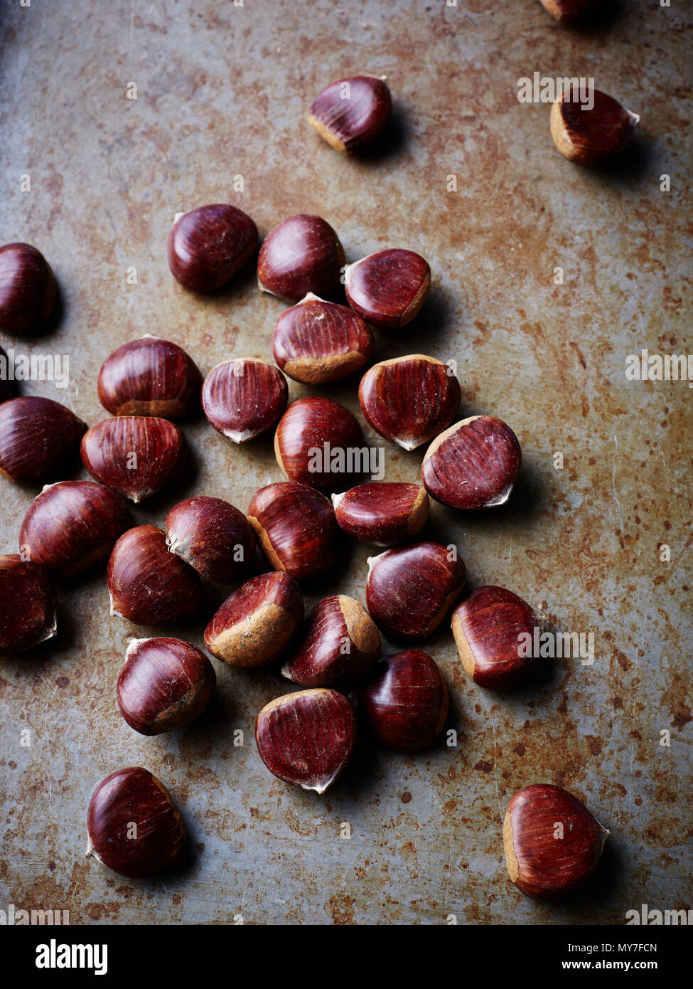 Chestnuts on rustic surface, close-up Stock Photo