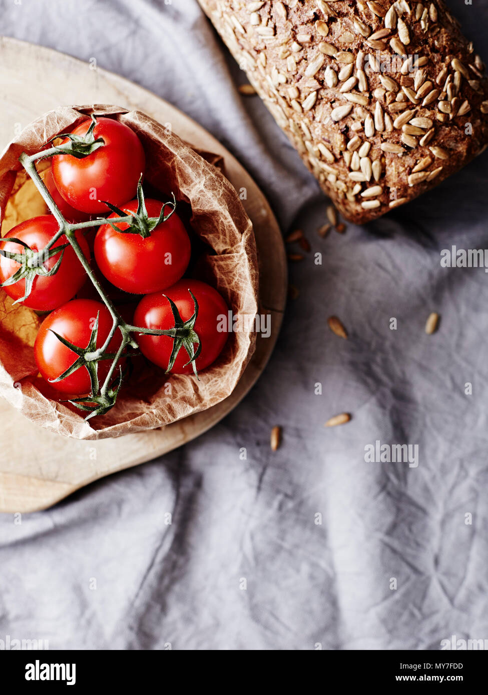 Still life of rye bread and vine tomatoes, overhead view Stock Photo
