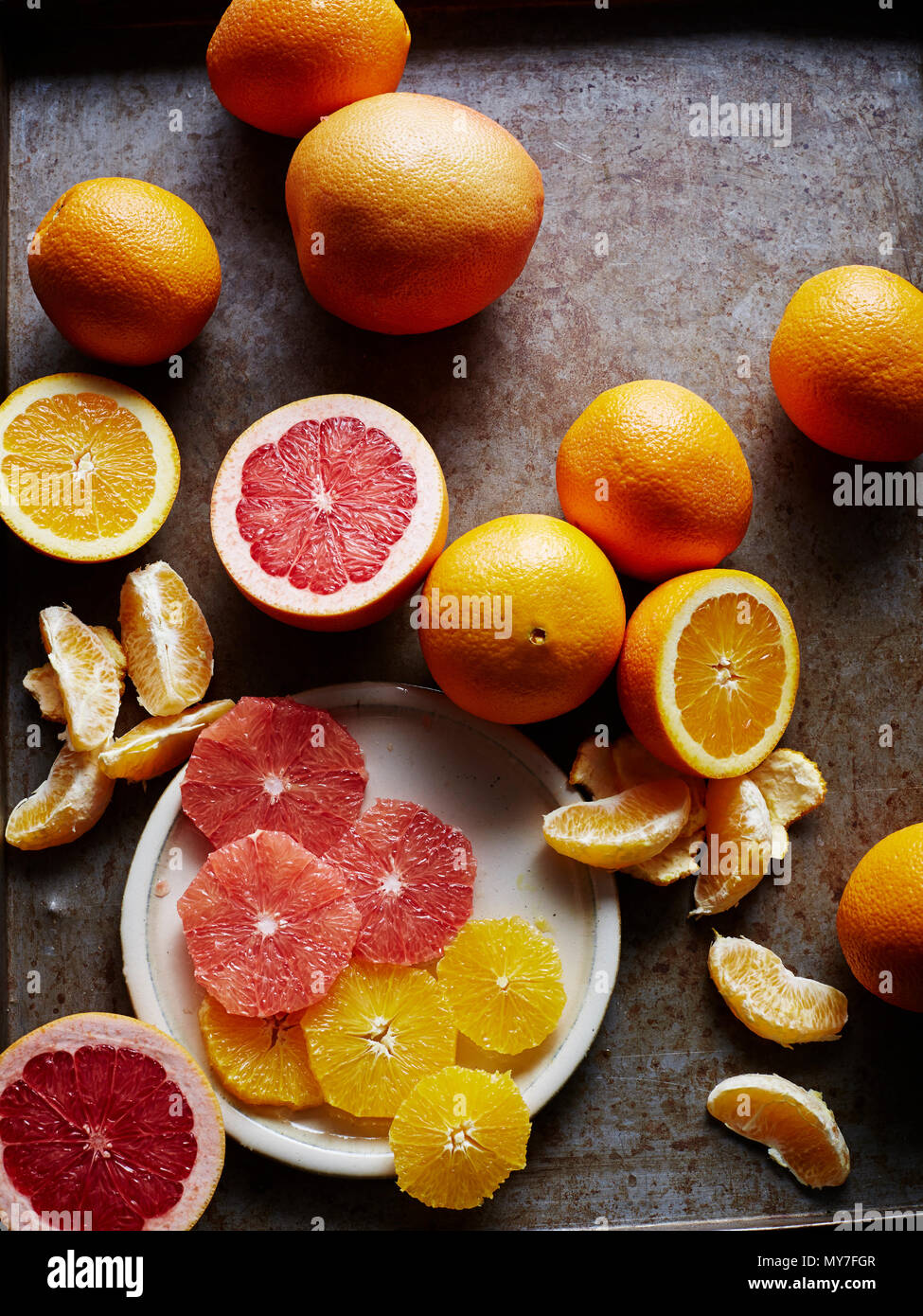 Still life with oranges and grapefruit, whole halved and sliced, overhead view Stock Photo