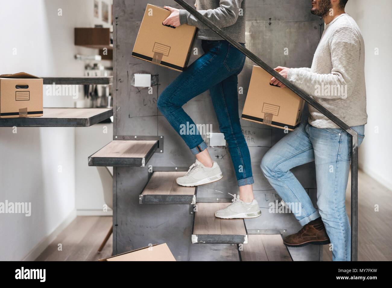 Couple carrying cardboard boxes up stairs Stock Photo Alamy