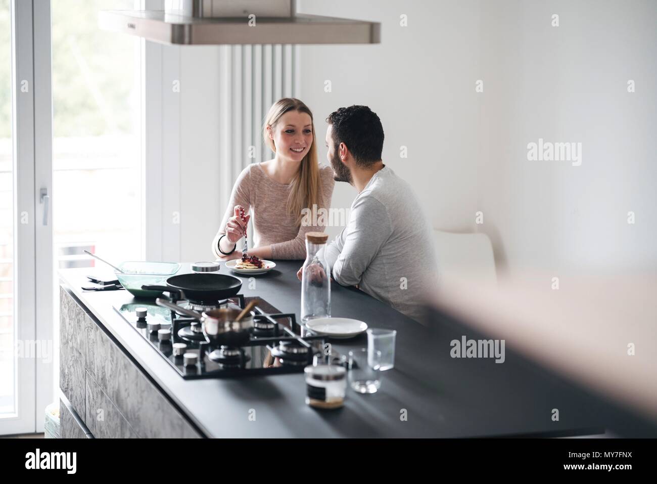 Couple in kitchen at breakfast bar Stock Photo