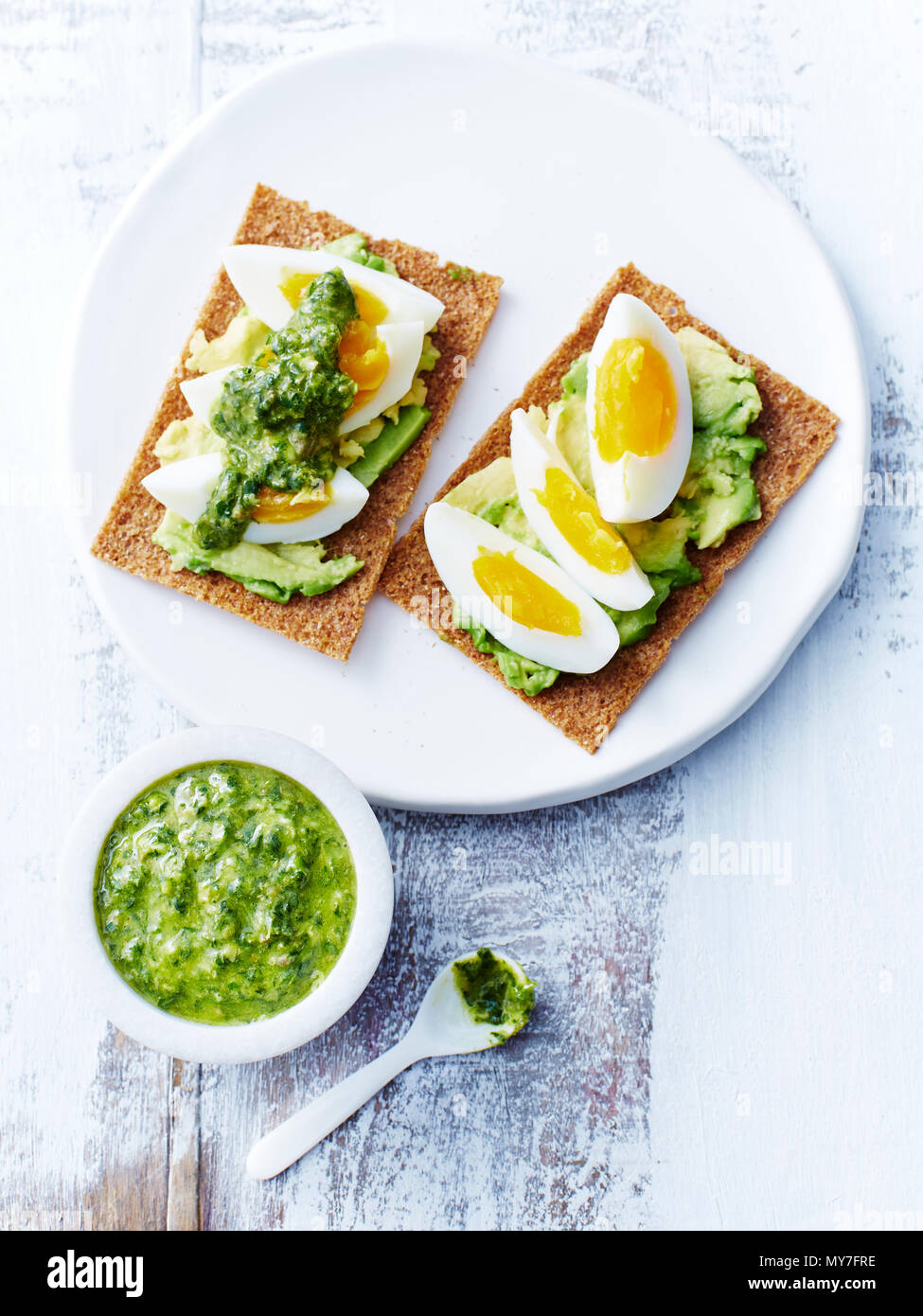 Salsa verde, eggs, avocado, rye crackers Stock Photo