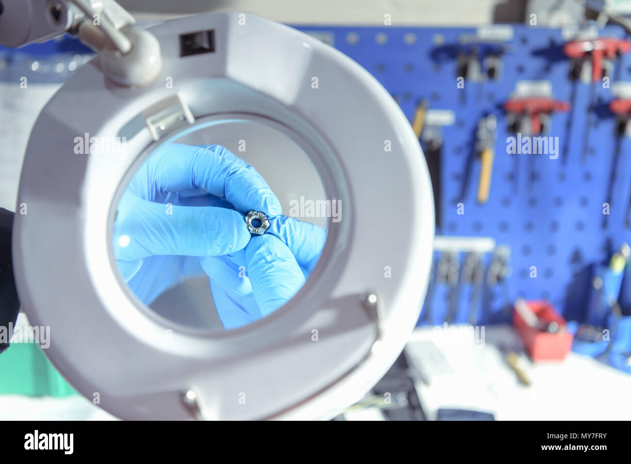 Close up of engineer using magnifier to inspect small part in engineering factory Stock Photo