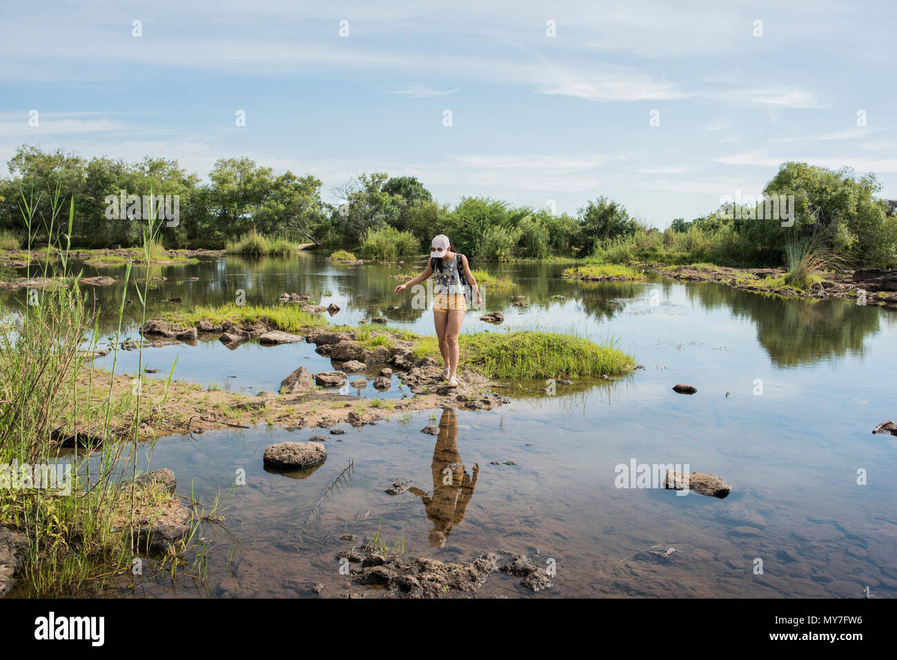 Young female tourist exploring calm waters near Victoria Falls, Zimbabwe, Africa Stock Photo
