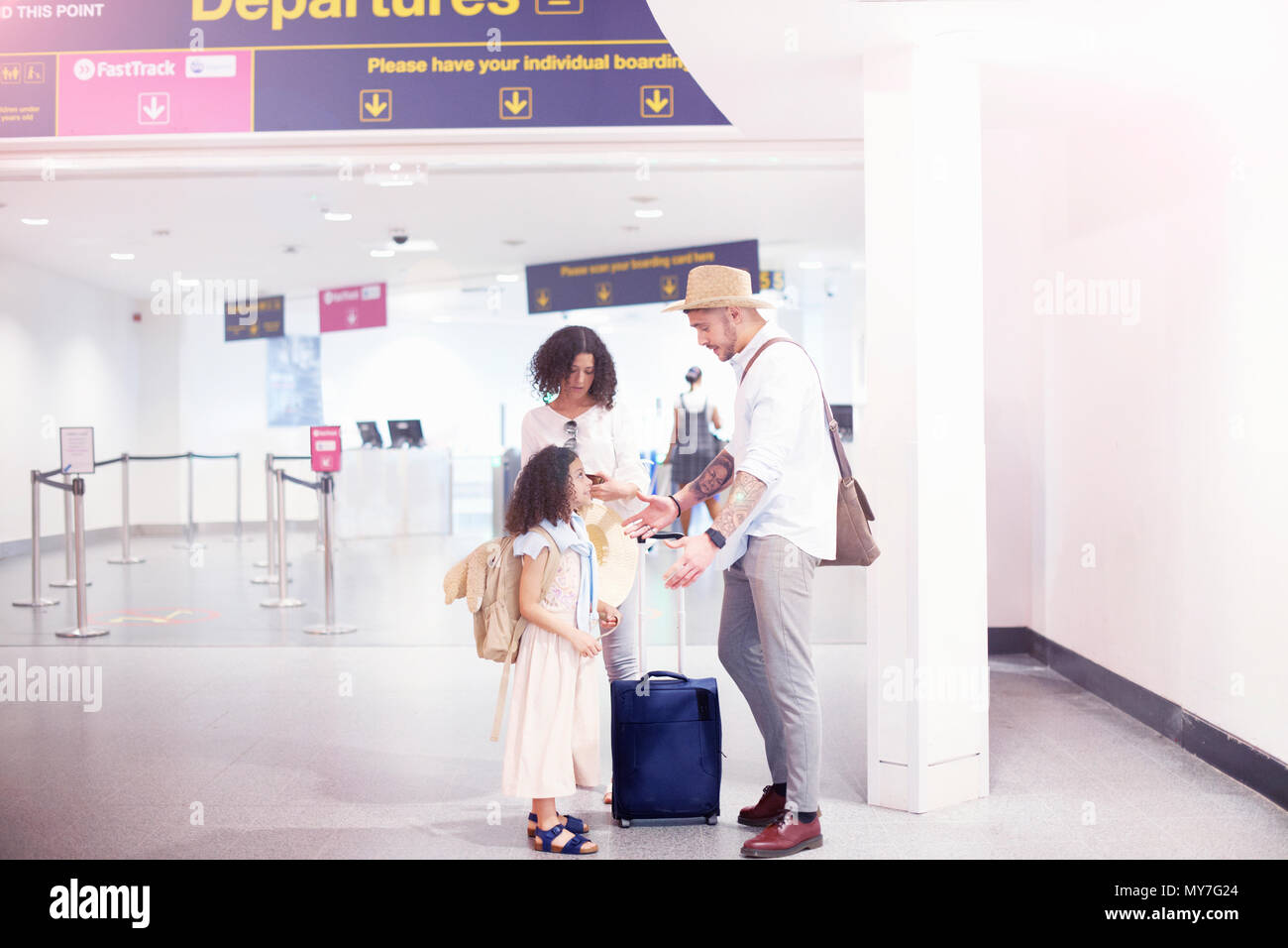 Family standing together at departure lounge of airport Stock Photo