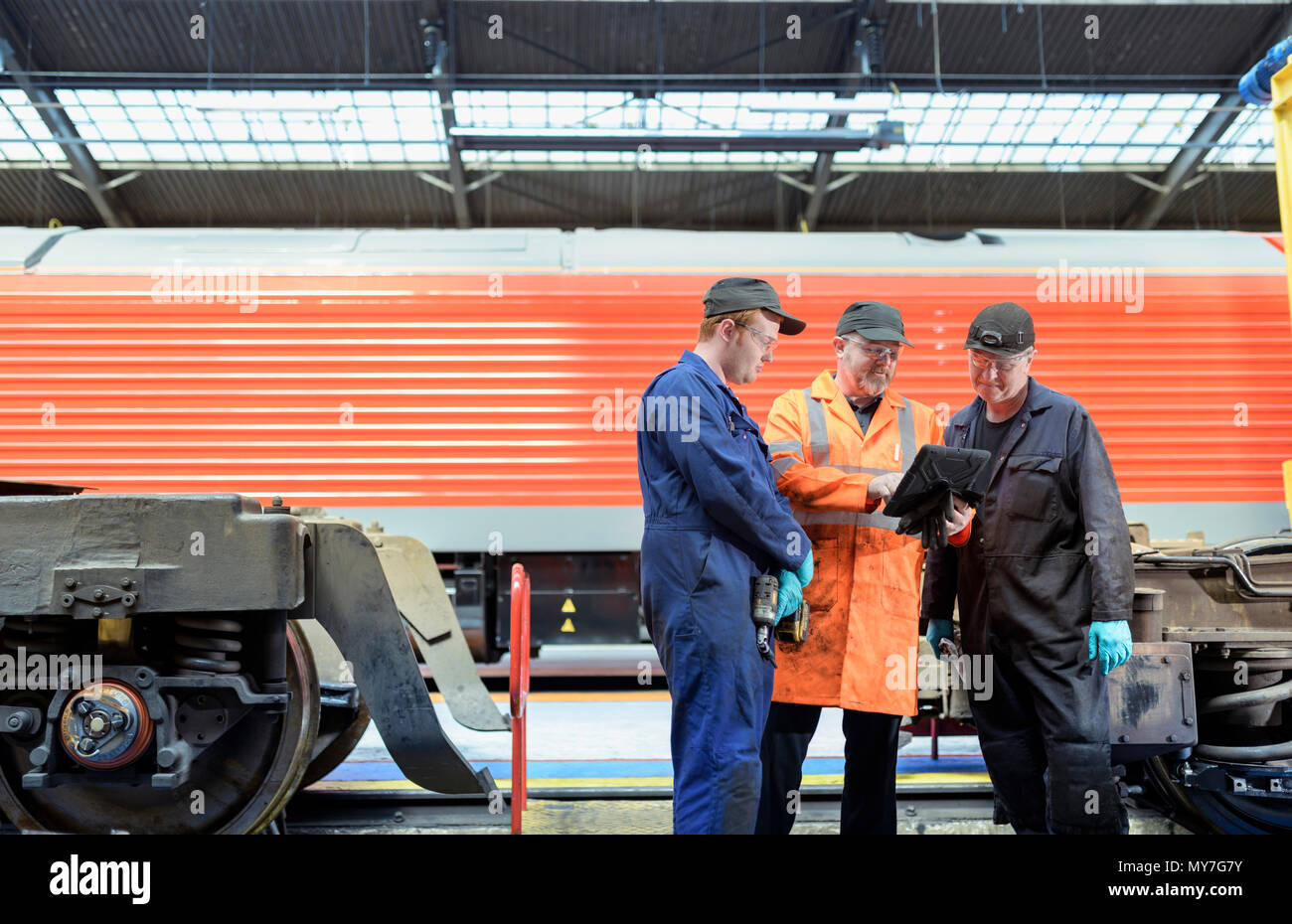 Engineers with digital tablet with refurbished train in train engineering factory Stock Photo