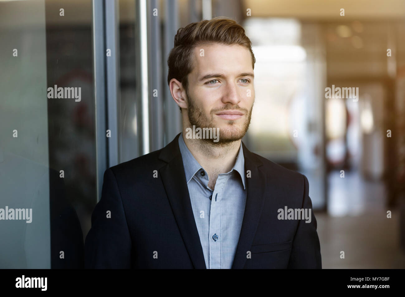 Portrait of young businessman in office corridor Stock Photo