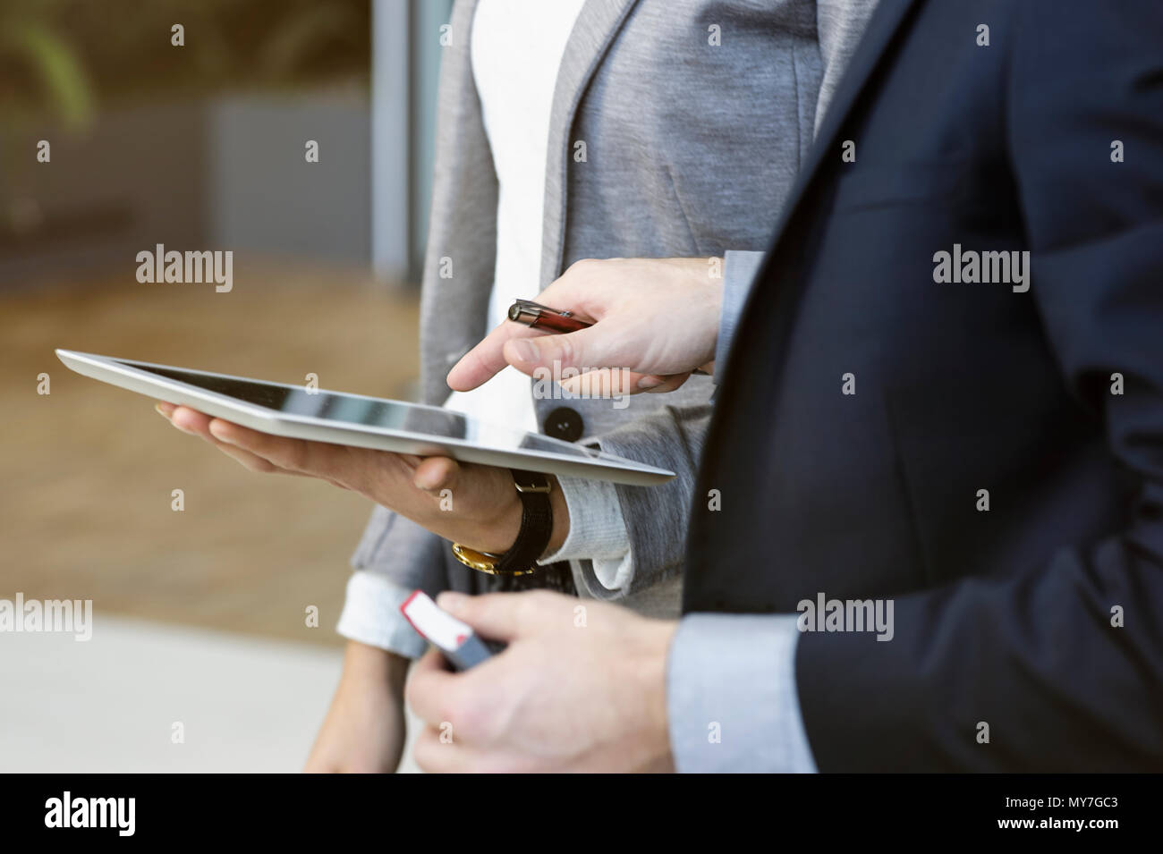 Businesswoman and man in office using digital tablet, mid section Stock Photo