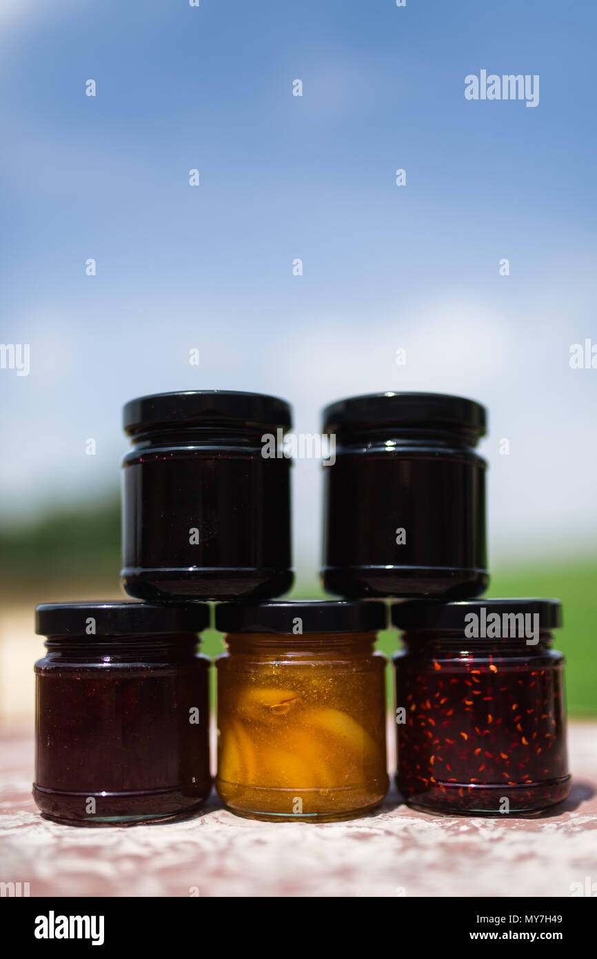 Jam jars each containing a different type of homemade fruit jam Stock