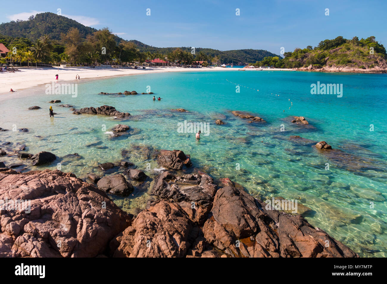 Beautiful scenic view of the rocky part of Long Beach (Pasir Panjang) on Redang Island in Terengganu, Malaysia. Tourists enjoying their leisure time. Stock Photo