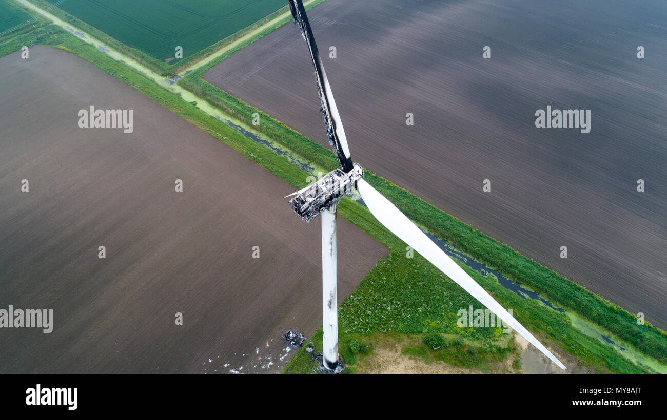 Aerial picture shows the wind turbine damaged by lightning in Doddington,Cambs on May 30th.   An 89m (292ft) wind turbine caught fire after storms hit Cambridgeshire overnight. Firefighters were called to the blaze at the top of the turbine in Benwick Road, Doddington, at about 07:50 BST.  Parts of it have broken off, with debris scattered in the area but there is no danger to the public, the fire service said. Residents reported thunder and lightning overnight. The cause of the fire is not yet known. Stock Photo