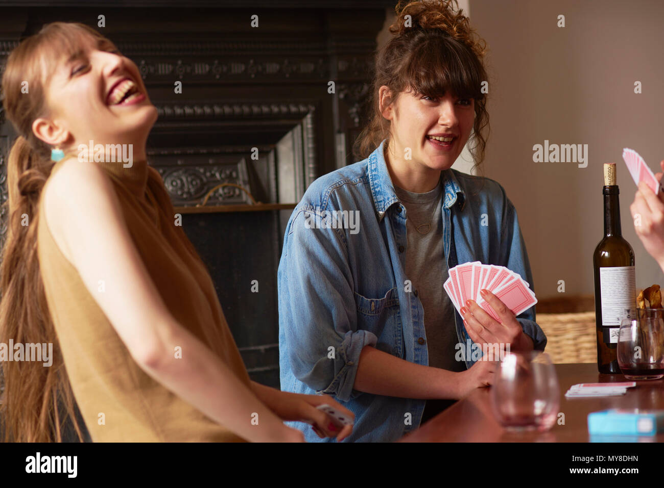 Friends playing cards in living room Stock Photo