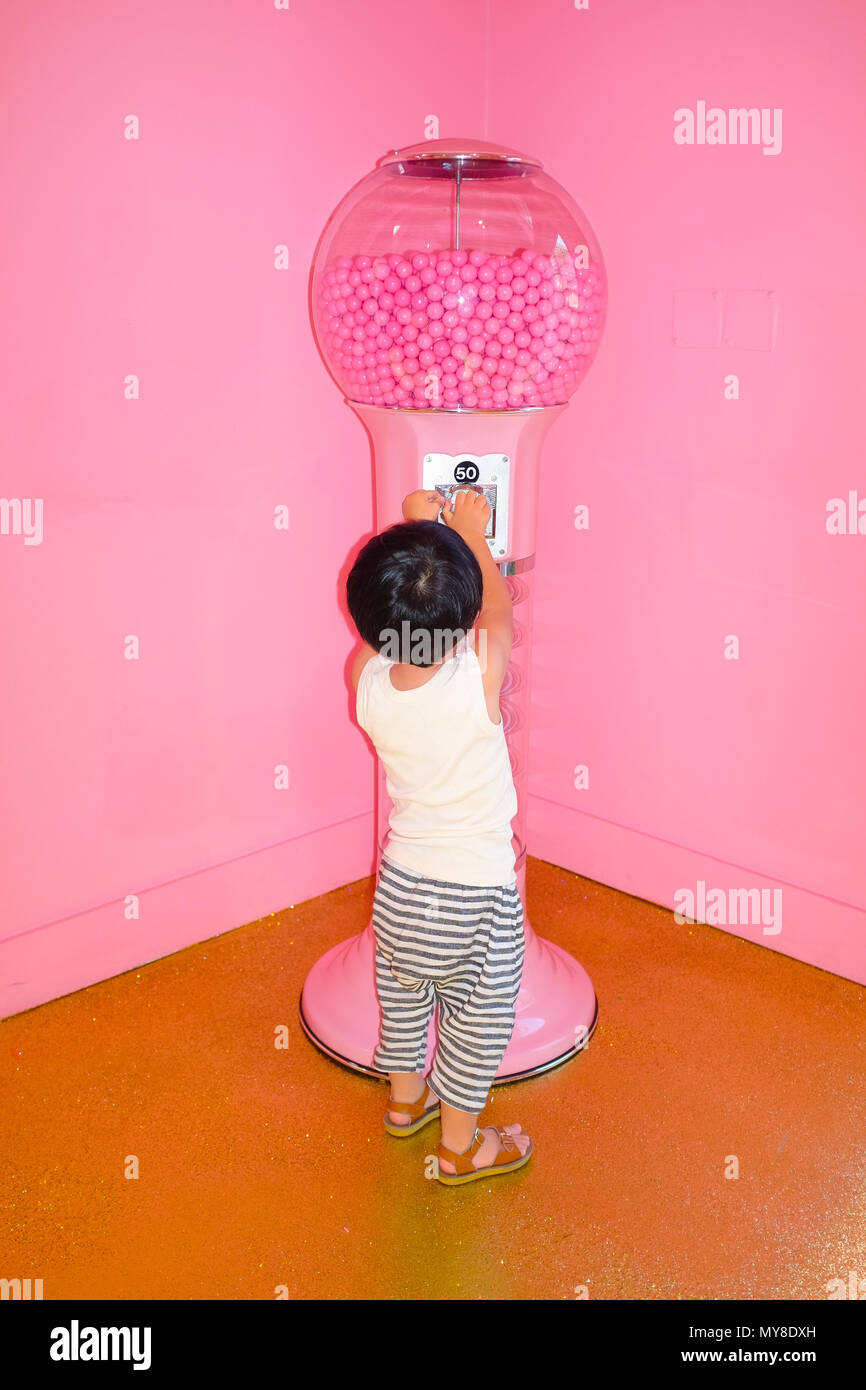 Download Little Boy Playing With Gumball Machine Stock Photo Alamy