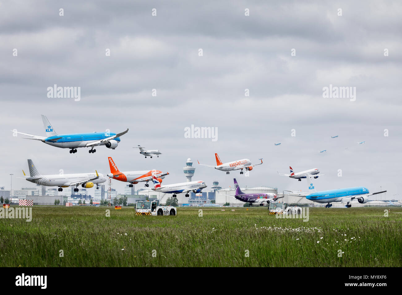 Stacked photo of multiple planes arriving, landing at Amsterdam Schiphol Airport. Stock Photo
