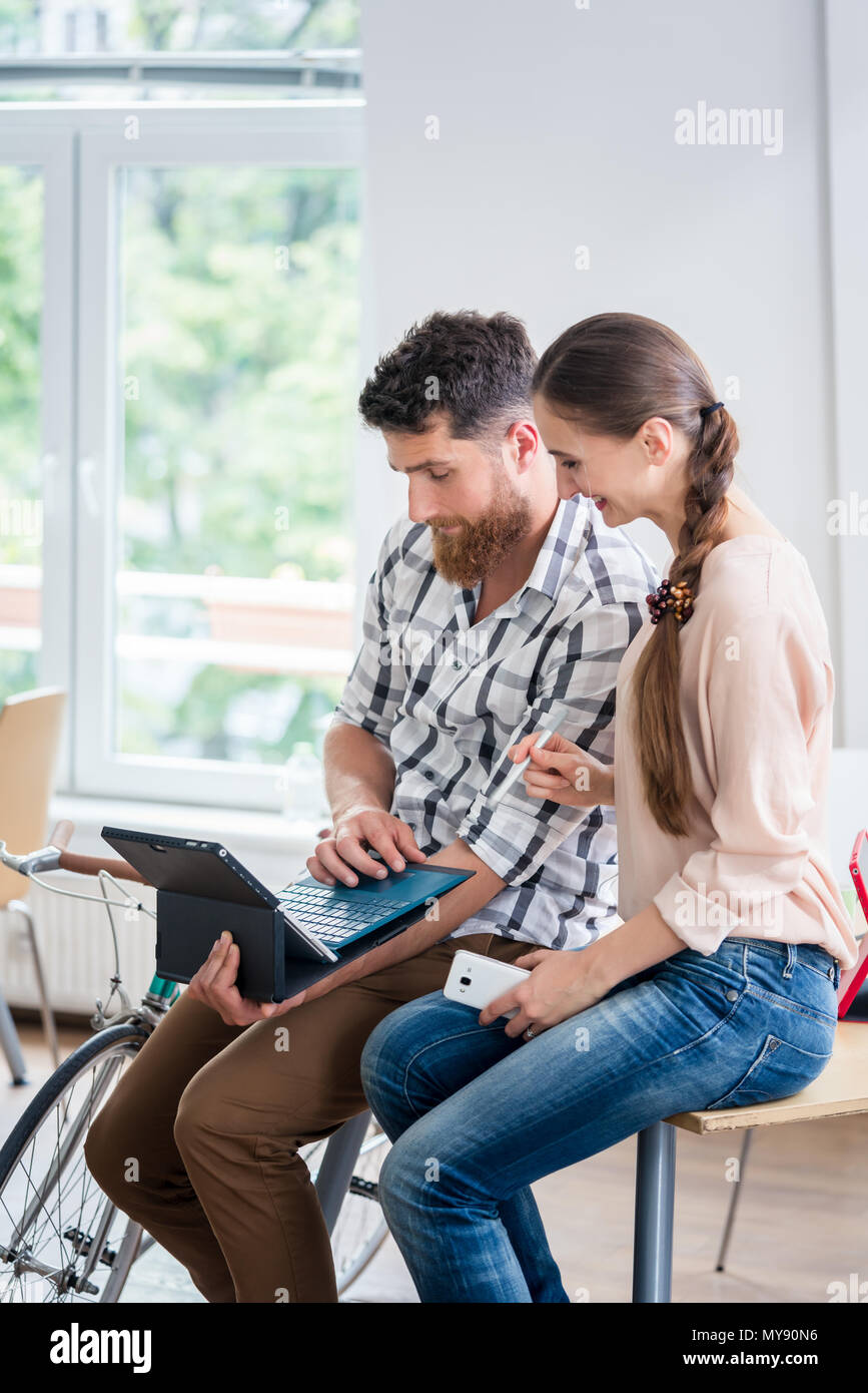 Cheerful young man collaborating with his female co-worker Stock Photo